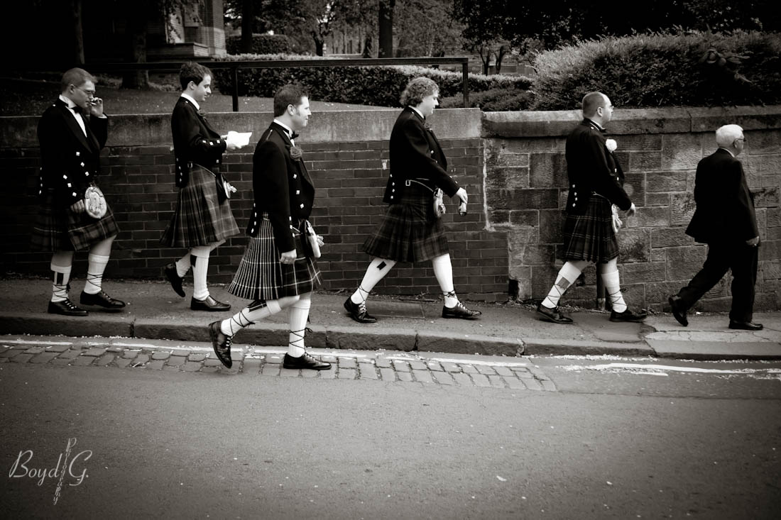 Groomsmen and groom walking down the street towards the ceremony in a line