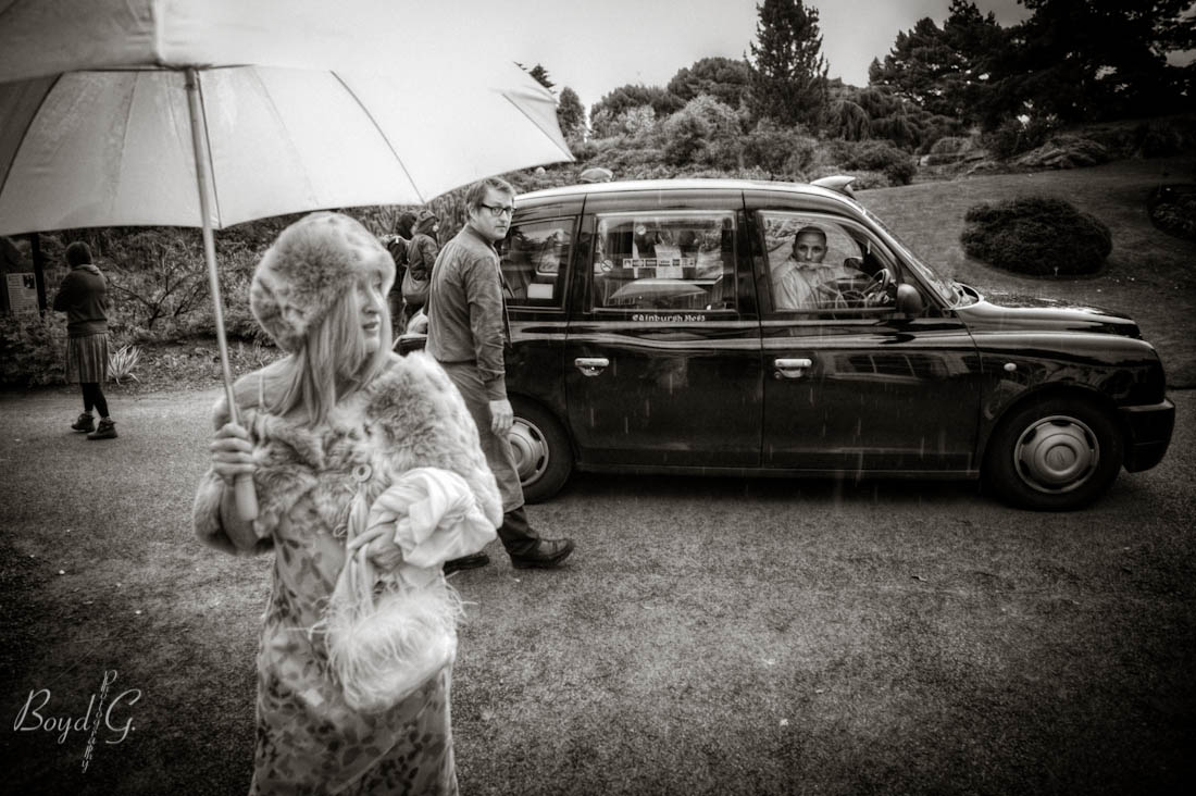 bridesmaid steps out of the car and is stared at by people passing by