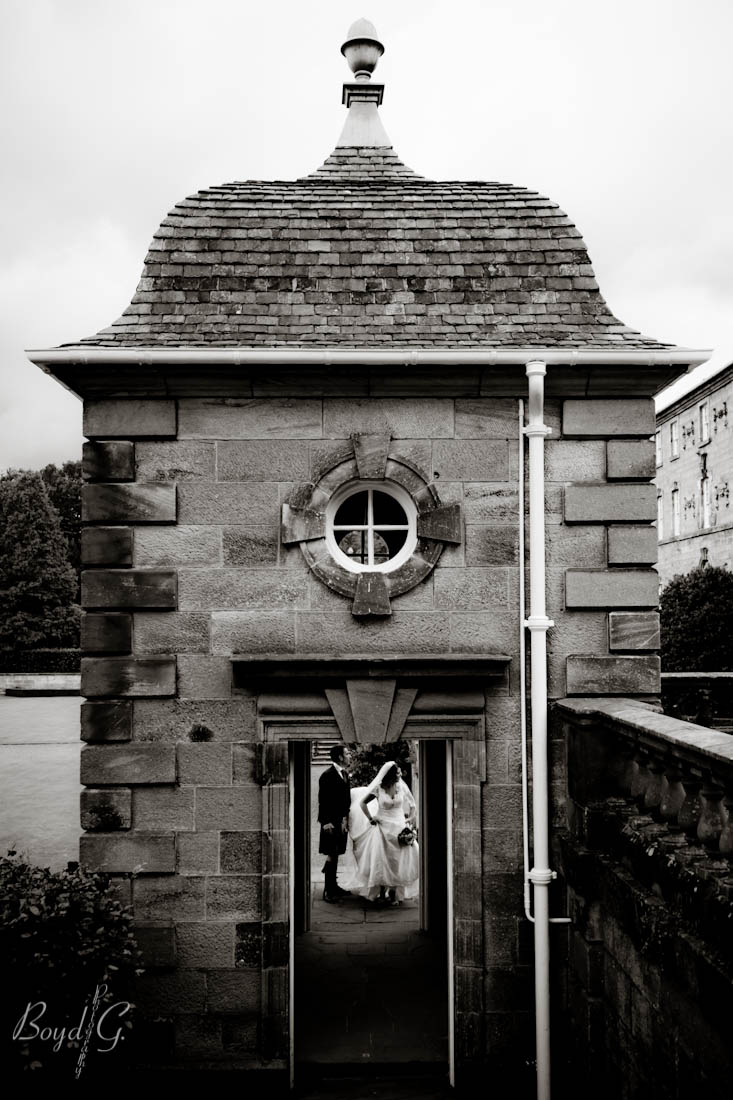 Bride groom framed perfectly in a doorway as they look up at their wedding guests