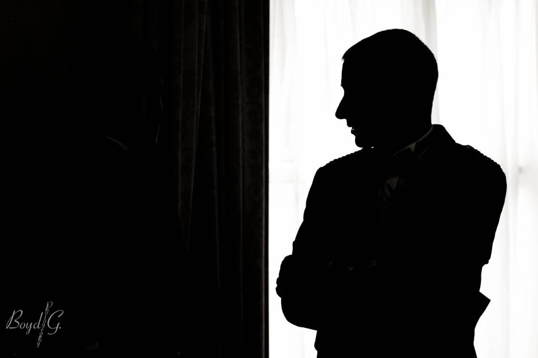 Simple and elegant silhouette of a groom talking to his mates at his wedding.  