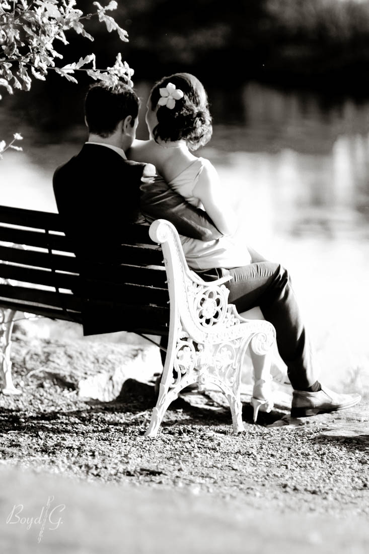 Bridesmaid sits with her husband on a bench and enjoys a quiet moment alone.